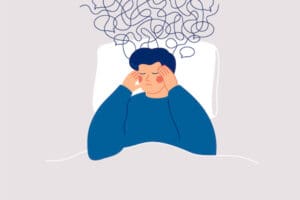 Intrusive thoughts of suicide illustrated by a drawing of a person holding their temples, lying on a pillow, while dark scribbles and speech bubbles shoot upward out of their head