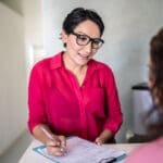 tms for major depression represented by a provider taking notes while talking to a patient