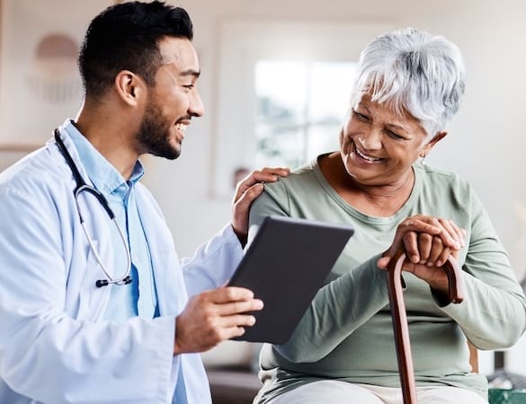 A young doctor sharing information about symptoms of Depression in older adults from his digital tablet with an older patient