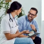 A doctor and patient engage in a friendly conversation about esketamine as a glutamate depression treatment