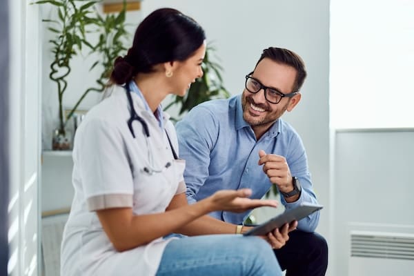 A doctor and patient engage in a friendly conversation about esketamine as a glutamate depression treatment